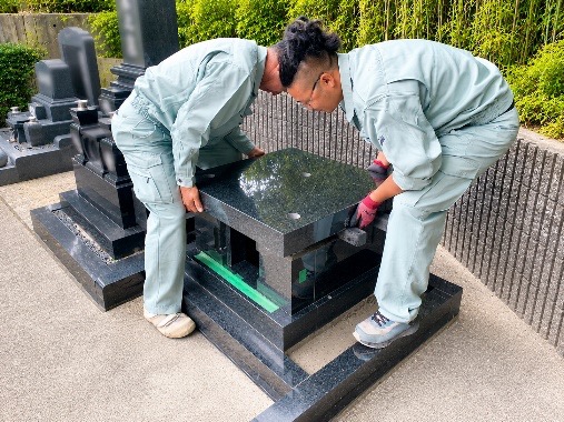 職人が墓石を据え付けている様子